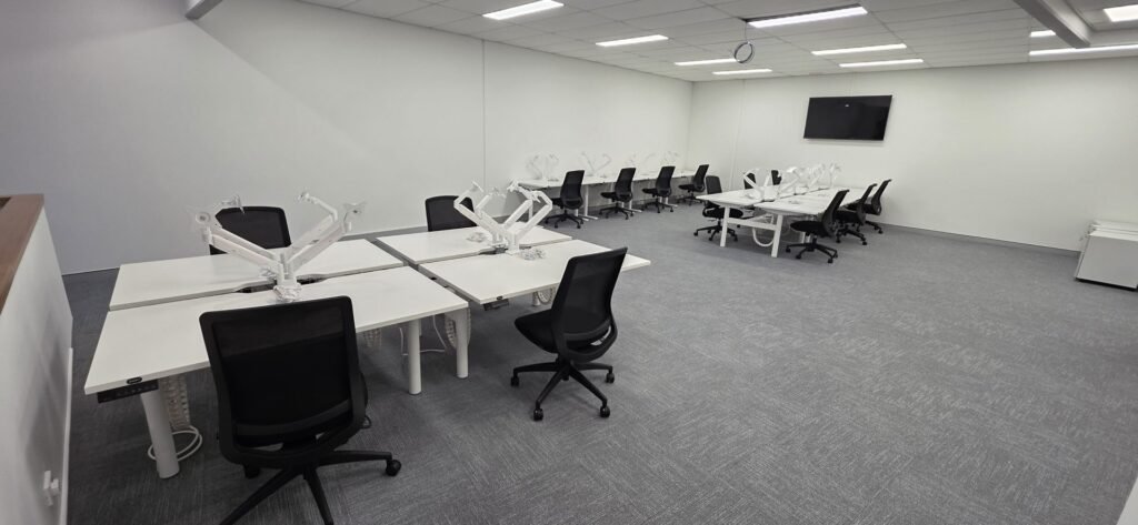 Fully fitted-out office room with white desks and chairs